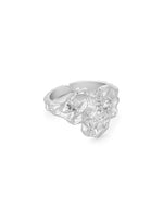 En sølvfarvet ring med en ujævn, skulpturel form er centreret mod en hvid baggrund. En lille diamant er indsat i ringens struktur.
