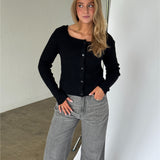 Modelbillede af AMANI boatneck strik cardigan i sort. Fra BySofieSønderby