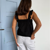 Modelfoto af pige som bærer en Amona top i sort, samt et par mørkeblå jeans. Alt fra By Sofie Sønderby