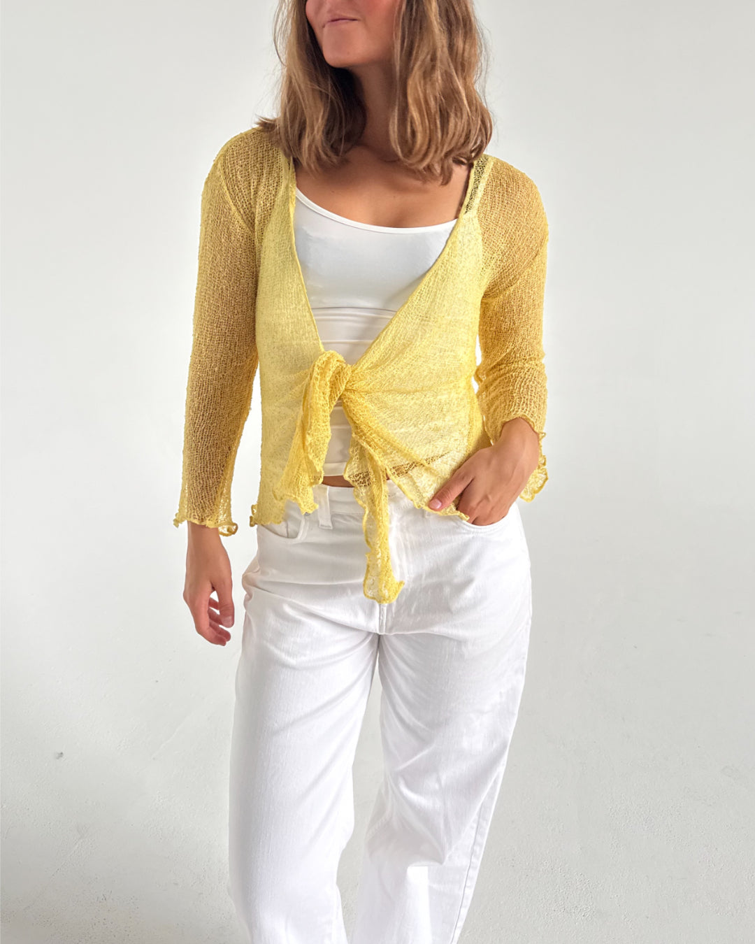 Modelfoto af pige som bærer en Arabella bluse i gul, samt et par hvide jeans. Alt fra By Sofie Sønderby