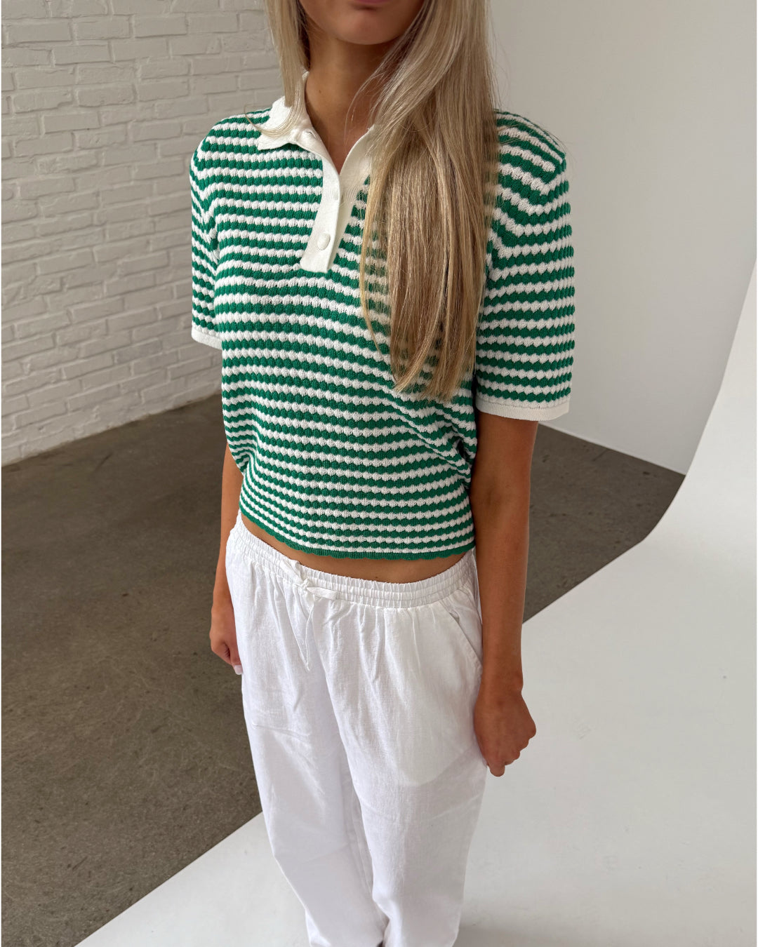 Modelfoto af pige iklædt ASHLEY polo, grøn og ZARA hørbukser, hvid - begge fra BySofieSønderby