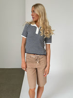 Modelfoto af pige iklædt ASHLEY polo, navy og AVERY jorts, sand - begge fra BySofieSønderby