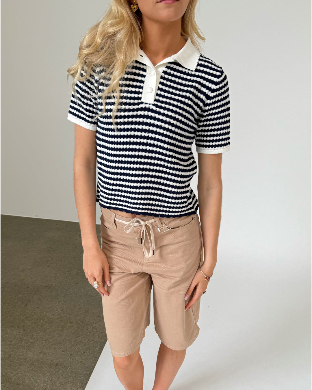 Modelfoto af pige iklædt ASHLEY polo, navy og AVERY jorts, sand - begge fra BySofieSønderby