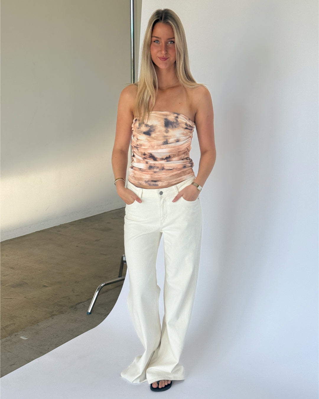 Modelbillede af BINE stropløs top, beige og NANNA wide leg jeans, hvid. Fra BySofieSønderby
