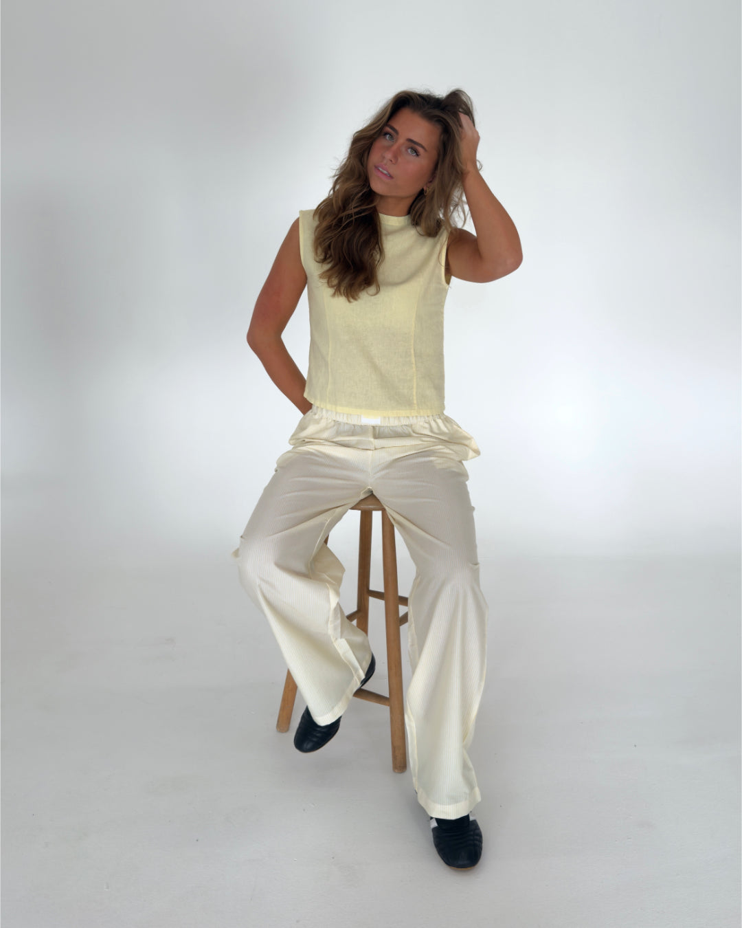 Modelfoto af pige i gulstribede CAJSA bukser, samt gul ANNIKA top. Alt er fra BySofieSønderby
