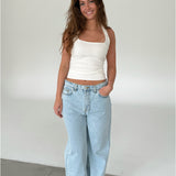 Modelfoto af pige med CHRISTINE top, hvid og NANNA jeans, lyseblå - begge fra fra BySofieSønderby