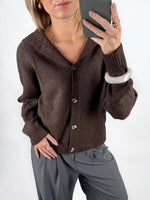 Modelfoto af pige i brun CLARE strik cardigan og grå LISA bukser. Alt er fra BySofieSønderby.