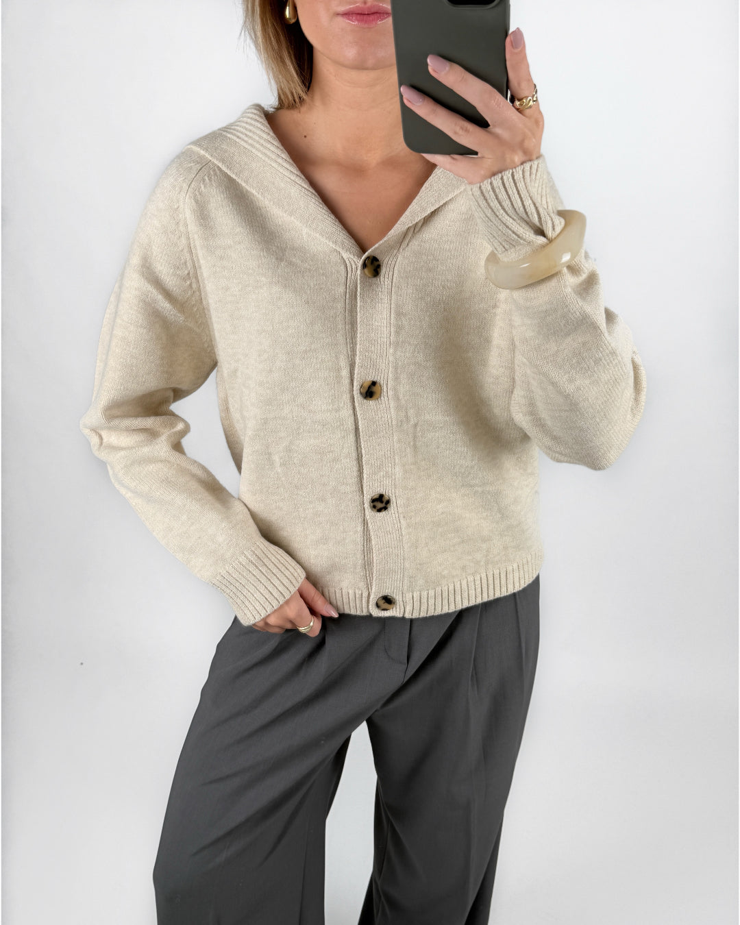 Modelfoto af pige i beige CLARE strik cardigan og grå LISA bukser. Alt er fra BySofieSønderby.