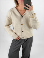 Modelfoto af pige i beige CLARE strik cardigan og grå LISA bukser. Alt er fra BySofieSønderby.