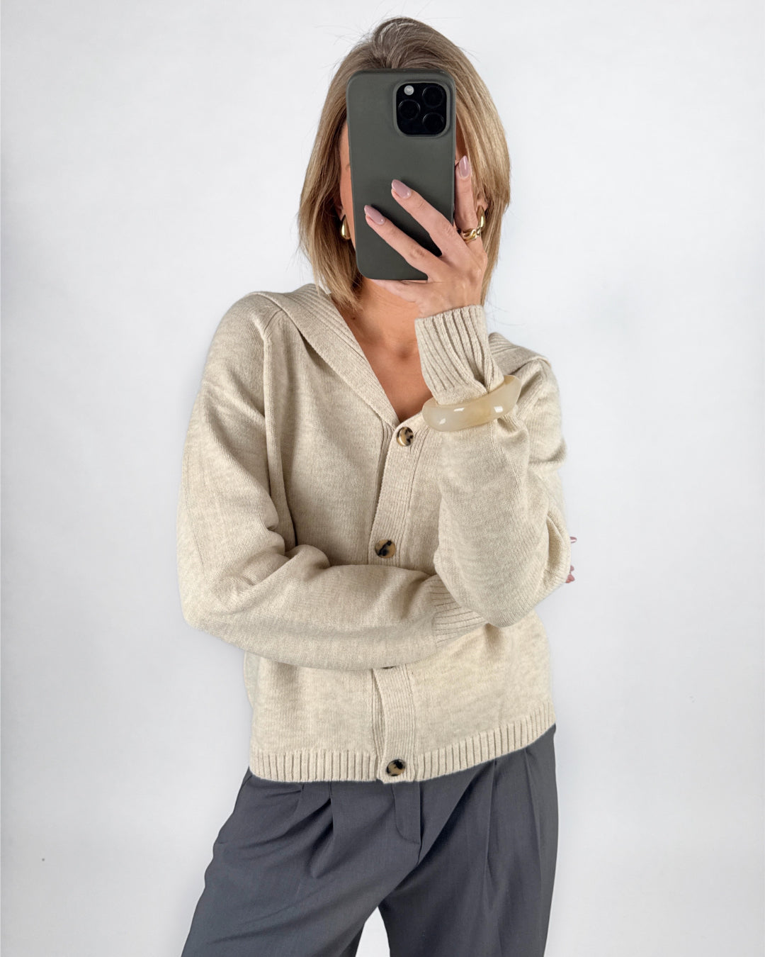 Modelfoto af pige i beige CLARE strik cardigan og grå LISA bukser. Alt er fra BySofieSønderby.