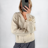 Modelfoto af pige i beige CLARE strik cardigan og grå LISA bukser. Alt er fra BySofieSønderby.