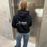 Stemningsbillede af pige der bærer en navy hoodie med hvidt classic tryk og blå NANNA jeans.  Fra BySofieSønderby
