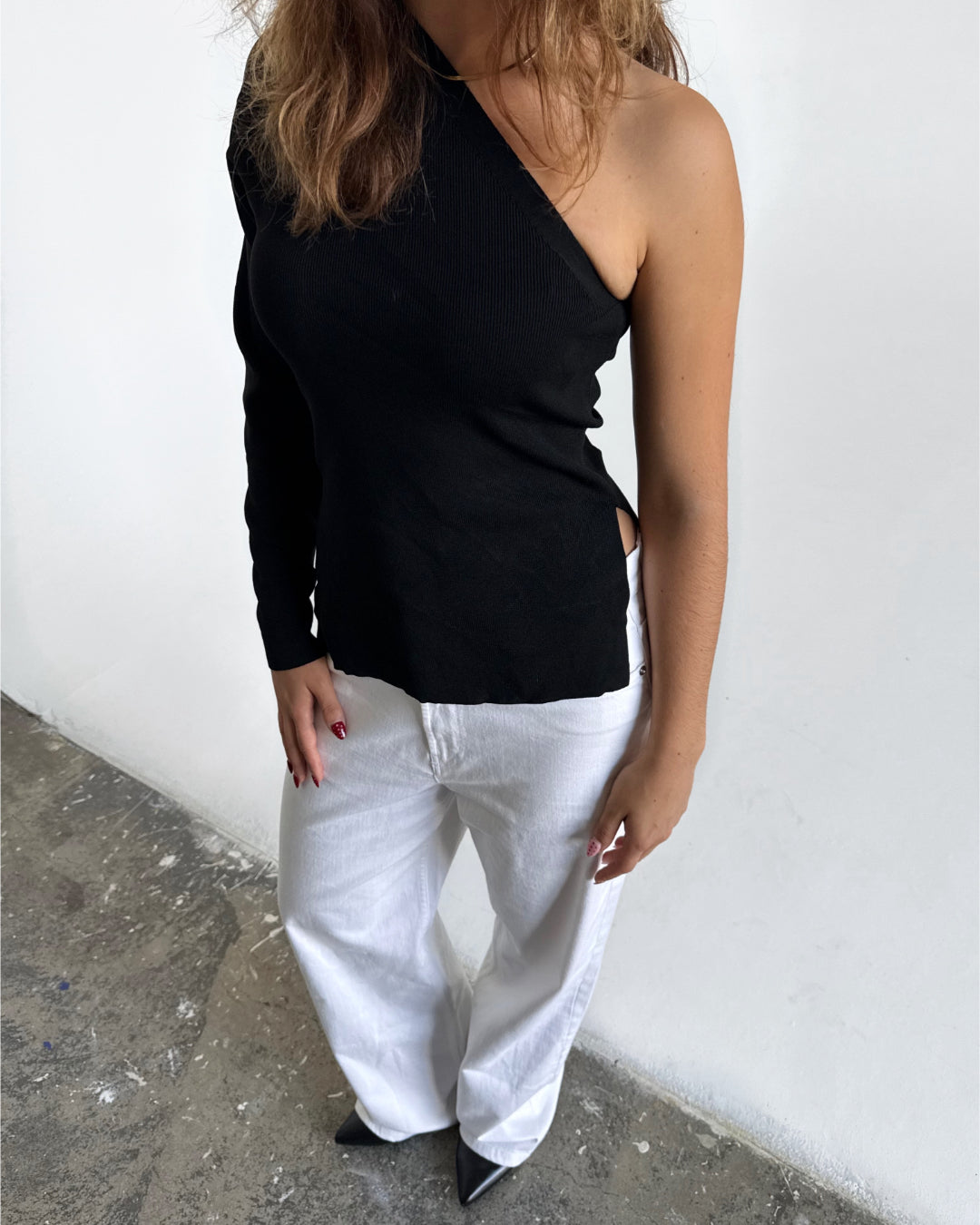 Modelfoto af pige i sort COLLINS one-shoulder, samt hvide NANNA jeans. Alt er fra BySofieSønderby