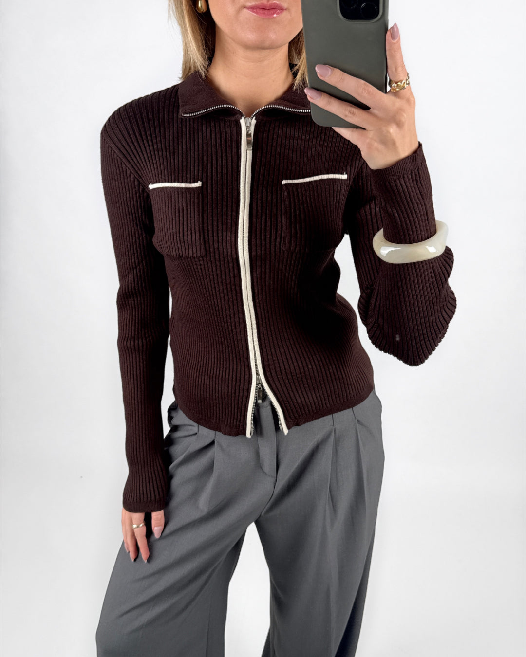 Modelfoto af pige i brun EMRYN zip-strik  og grå LISA bukser. Alt er fra BySofieSønderby.