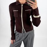 Modelfoto af pige i brun EMRYN zip-strik  og grå LISA bukser. Alt er fra BySofieSønderby.