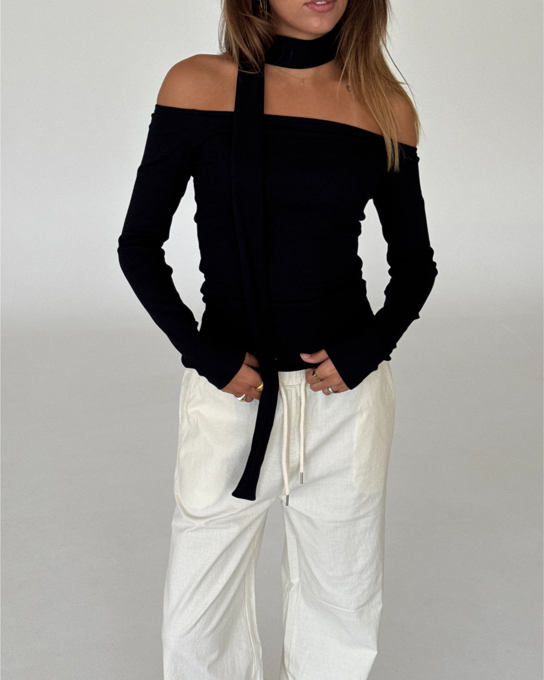 Modelbillede af FEO off shoulder bluse, sort og ELLEN bukser, creme. Begge fra BySofieSønderby