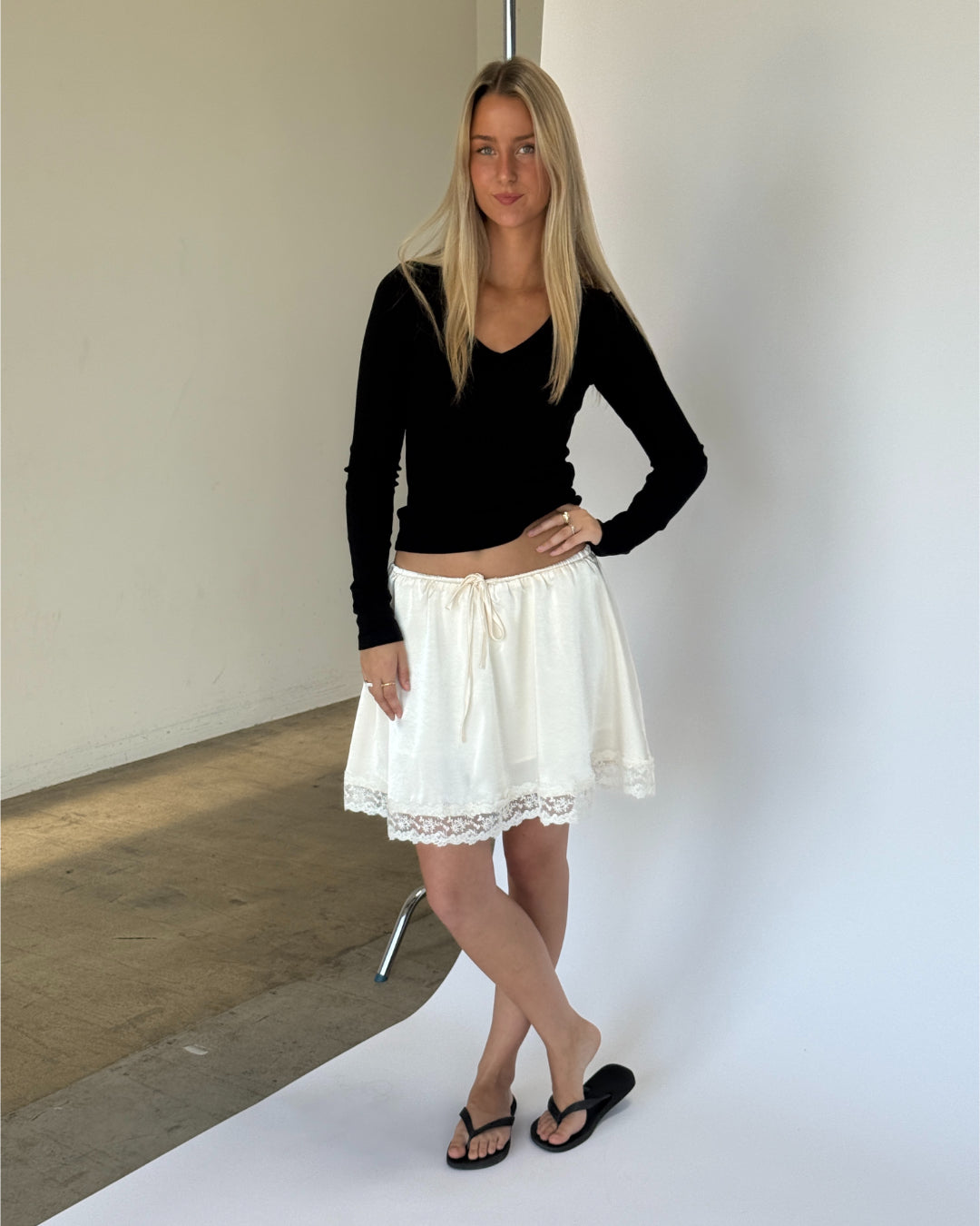 Modelbillede af FREYA langærmet v-hals, sort og LIZZY nederdel, creme. Begge fra BySofieSønderby