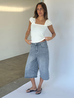 Modelbillede af GISELLE top, hvid og MADDIE denim jorts, blå. Fra BySofieSønderby