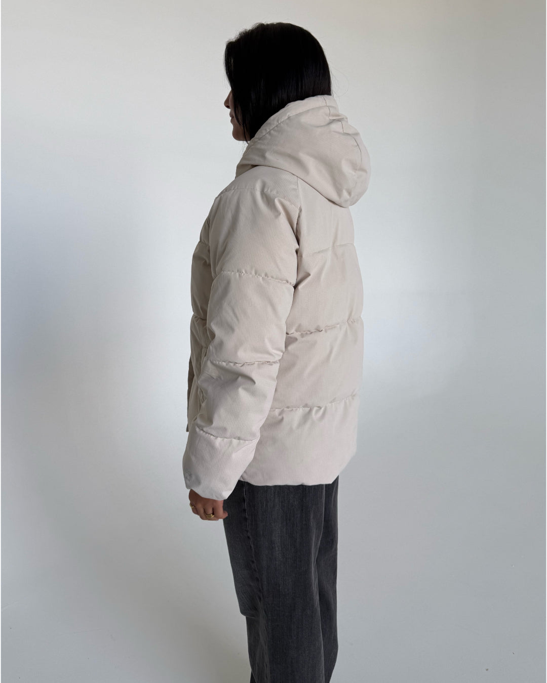Modelfoto af pige i cremefarvet GLOBAL vinterjakke, samt grå NANNA jeans. Alt er fra BySofieSønderby