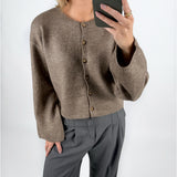 Modelfoto af pige i brun HADLEE cardigan, og grå LISA bukser. Alt er fra BySofieSønderby.