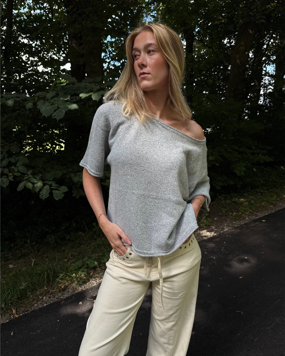 Modelfoto af pige i grå Karsyn wideneck  t-shirt og cremefarvede Adrianna jeans. Alt er fra BySofieSønderby