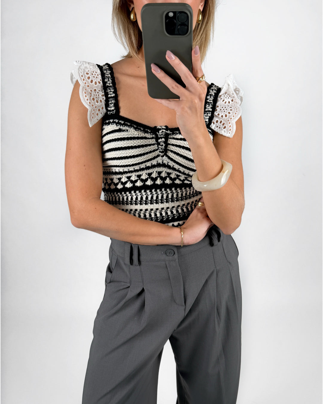 Modelfoto af pige i hvid KENDRA top med sorte detaljer, samt grå LISA bukser. Alt er fra BySofieSønderby.