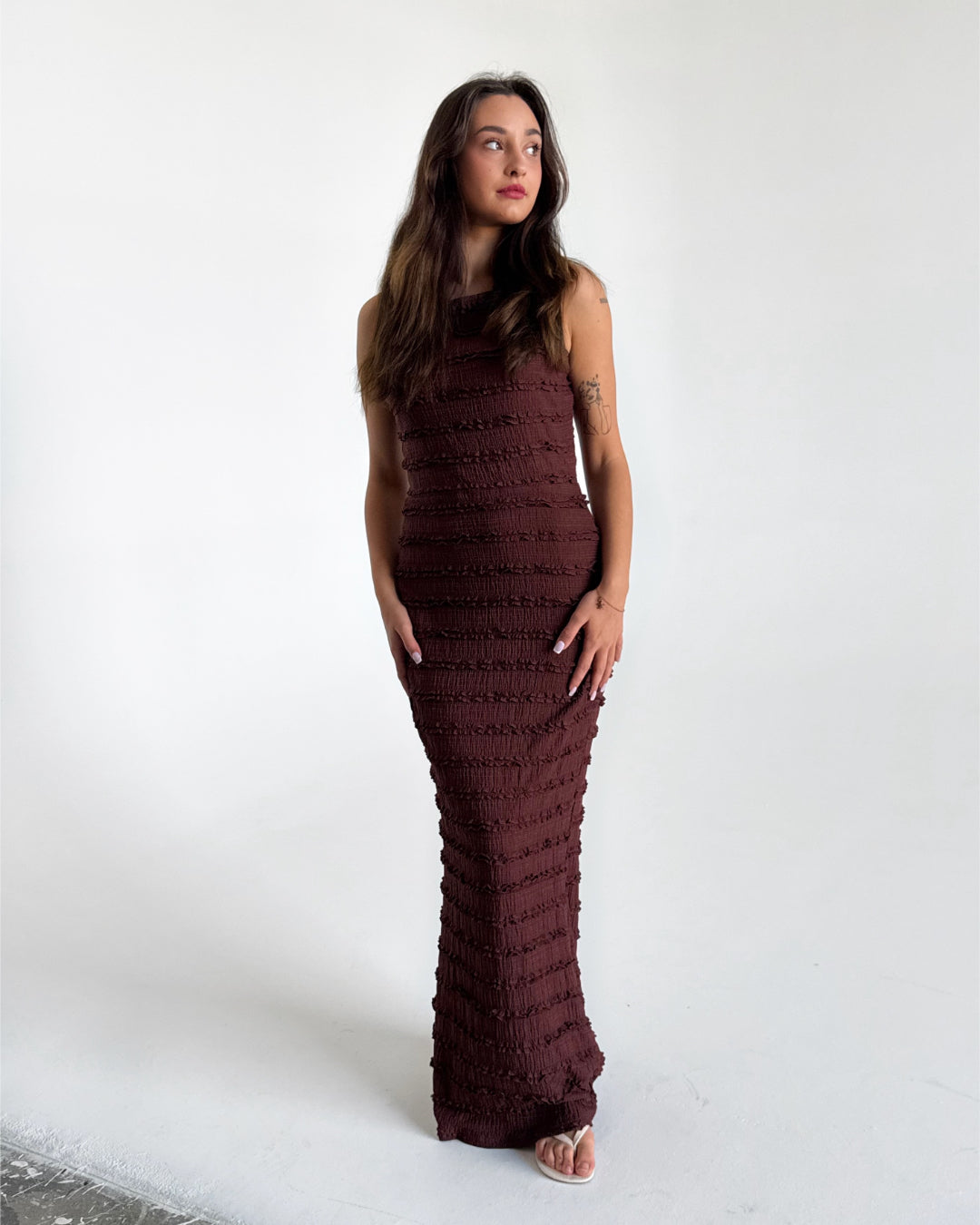 Modelfoto af pige i brun KIMBERLY kjole. Kjolen har tværgående detaljer. Alt er fra BySofieSønderby