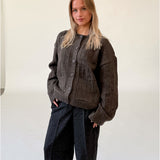 Modelfoto af pige i brun LACEY cardigan, samt sortmelerede ELLIS bukser. Alt er fra BySofieSønderby.