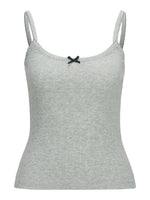 Grå tanktop med stropper og en sort sløjfe foran. Baggrunden er hvid, hvilket giver fokus på selve toppen.