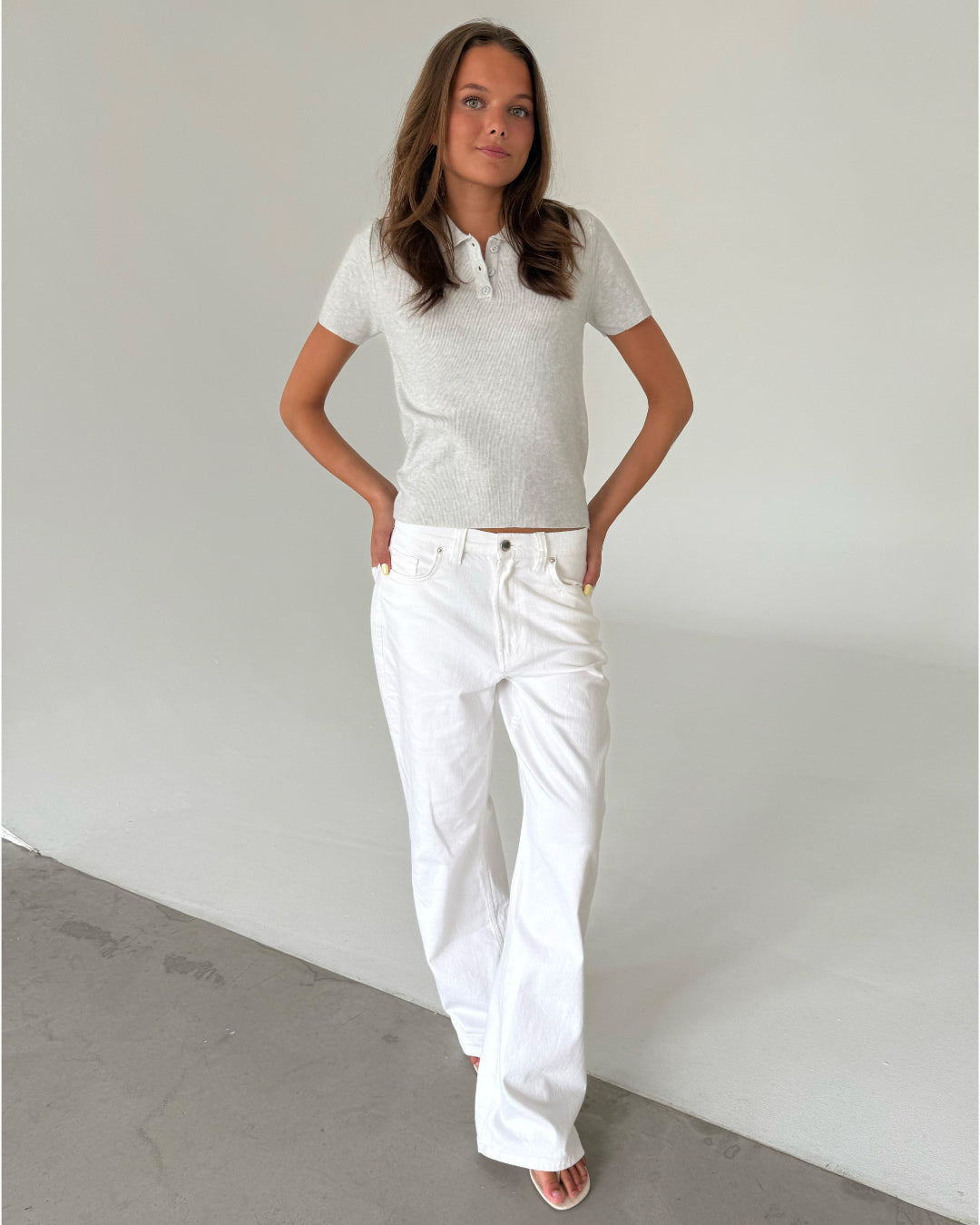 Modelfoto af pige med LILOU polo, grå og NANNA jeans, hvid - begge fra BySofieSønderby