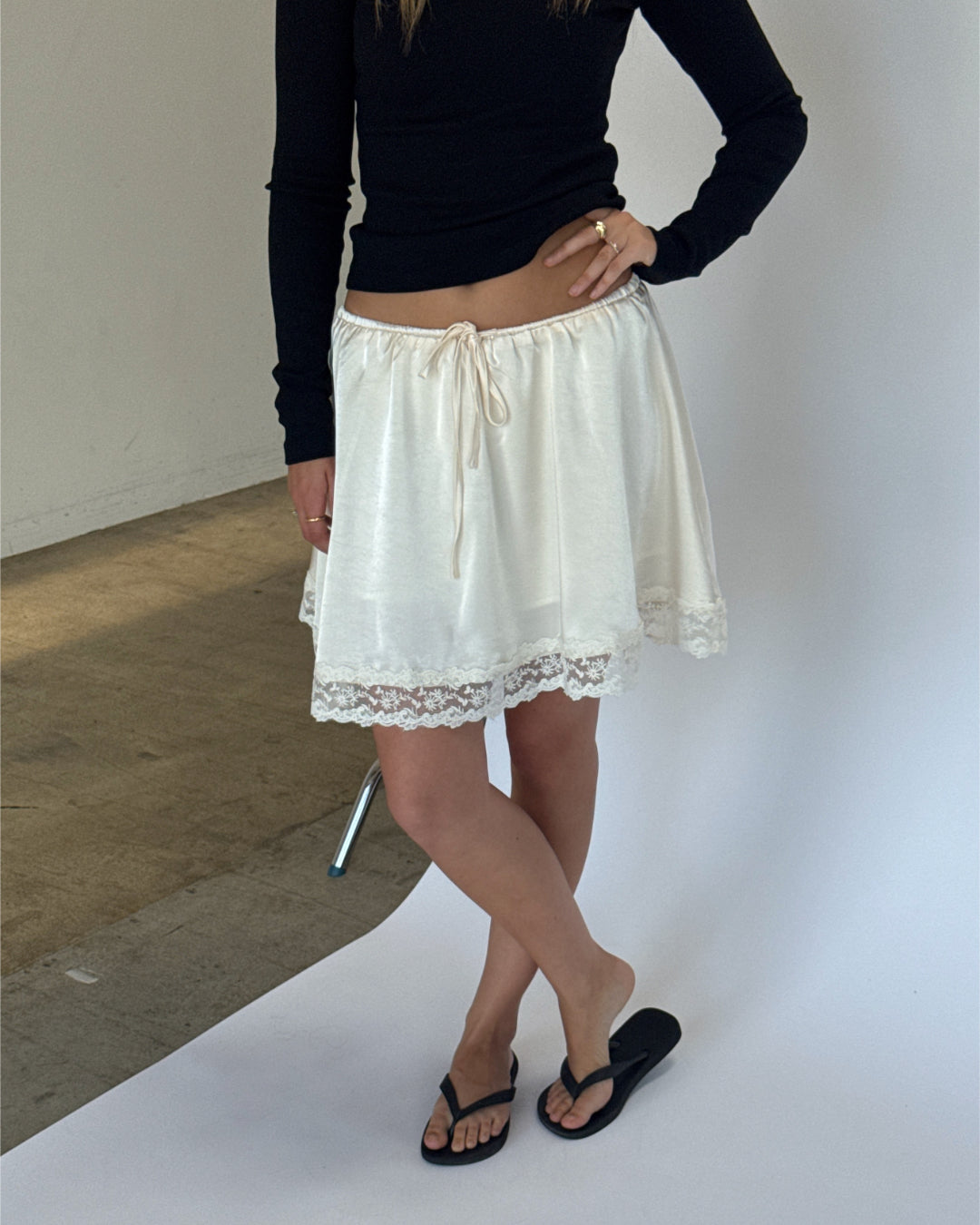 Modelbillede af LIZZY nederdel, creme og FREYA langærmet v-hals, sort. Fra BySofieSønderby