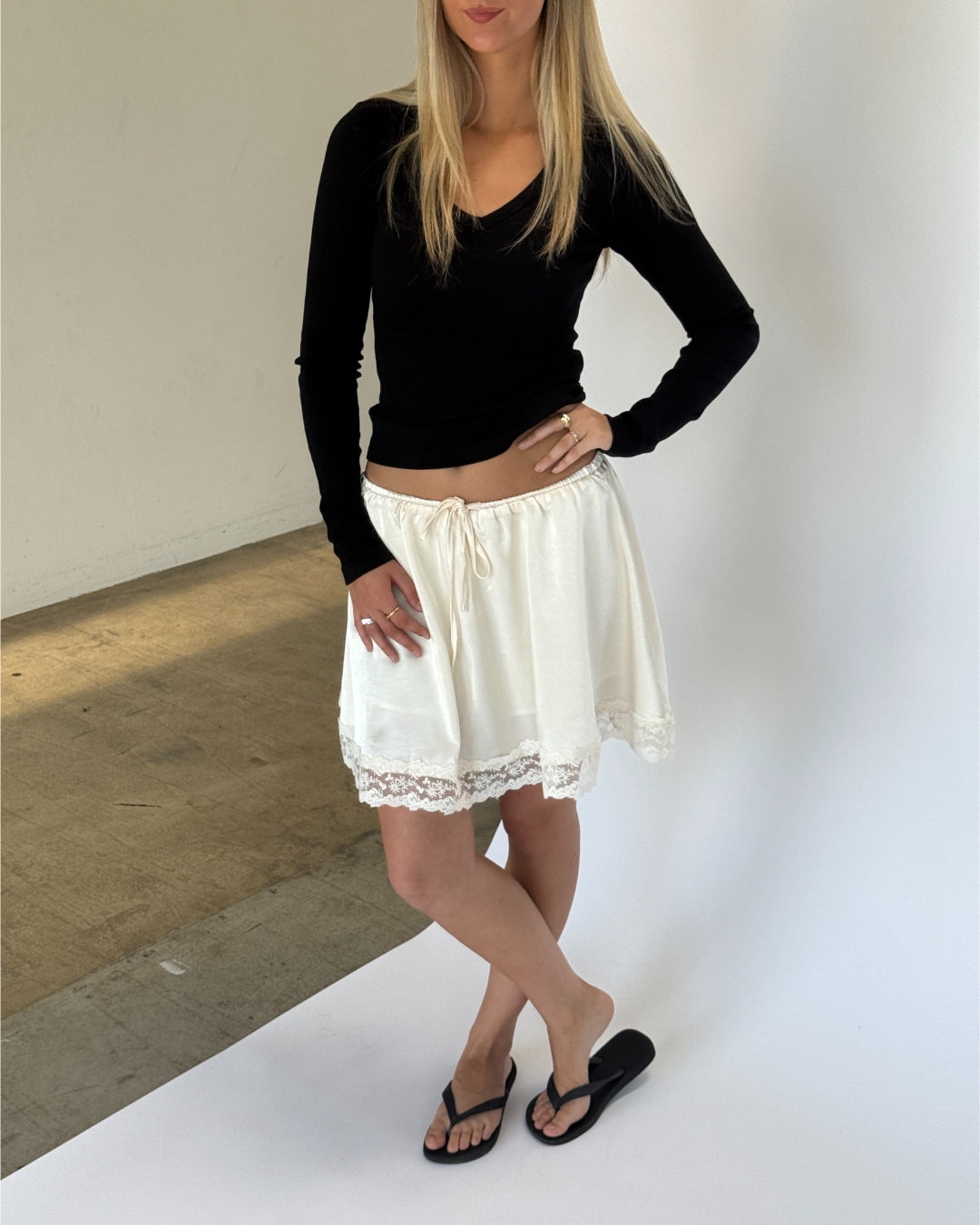 Modelbillede af LIZZY nederdel, creme og FREYA langærmet v-hals, sort. Fra BySofieSønderby