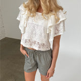 Modelfoto af pige iklædt LUCILLE blonde bluse, hvid og LANA shorts, grøn - begge fra BySofieSønderby