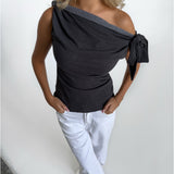 Modelfoto af pige i grå MAISIE off-shoulder, samt hvide NANNA jeans. Alt er fra BySofieSønderby