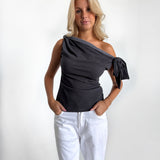 Modelfoto af pige i grå MAISIE off-shoulder, samt hvide NANNA jeans. Alt er fra BySofieSønderby