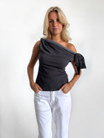 Modelfoto af pige i grå MAISIE off-shoulder, samt hvide NANNA jeans. Alt er fra BySofieSønderby