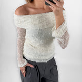 Modelfoto af pige i cremefarvet MAISY off-shoulder blondebluse og grå LISA bukser. Alt er fra BySofieSønderby.