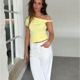 Modelfoto af pige med MILENA off shoulder top, gul og NANNA jeans, hvid - begge fra BySofieSønderby