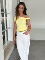 Modelfoto af pige med MILENA off shoulder top, gul og NANNA jeans, hvid - begge fra BySofieSønderby