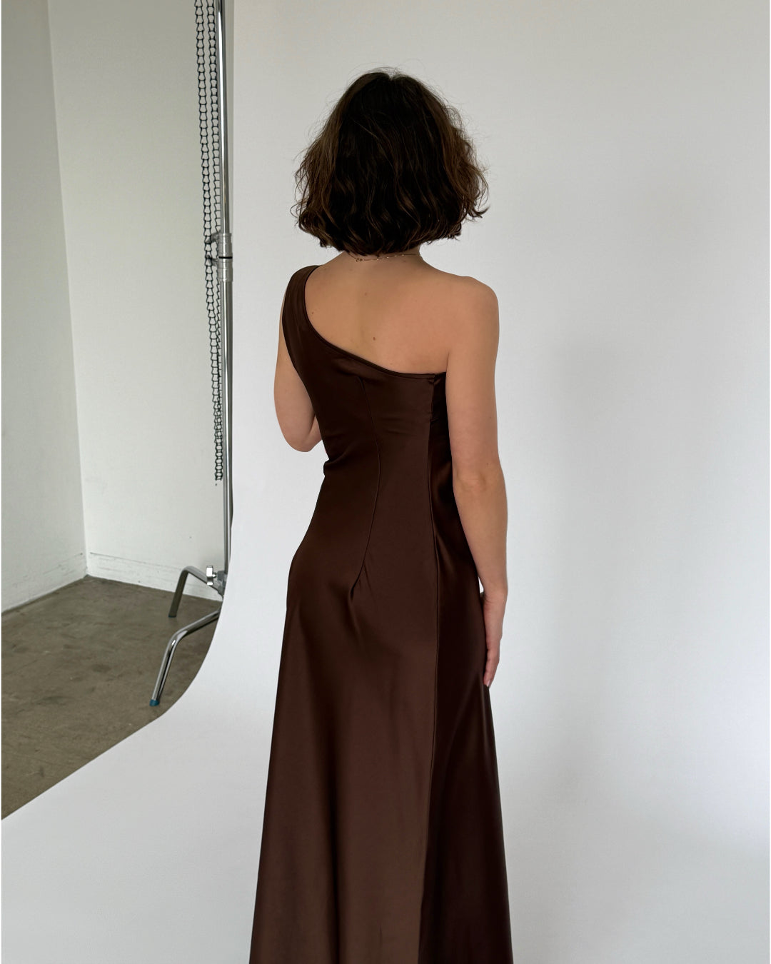 Modelbillede af brun NAT one shoulder kjole. Set bagfra. Fra BySofieSønderby