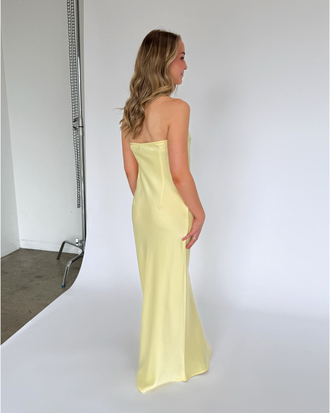 Modelbillede af gul NAT stropløs/bandeau kjole. Set bagfra. Fra BySofieSønderby