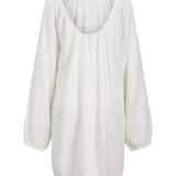 Hvid løstsiddende bluse med lange ærmer hænger frit mod en neutral baggrund. Stoffet har en let, krøllet tekstur, og blusen har en rund udskæring.