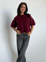 Modelfoto af pige i bordeaux Poppy strik t-shirt og grå Nanna jeans. Alt er fra BySofieSønderby