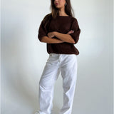 Modelfoto af pige i brun Poppy strik t-shirt og hvide Nanna jeans. Alt er fra BySofieSønderby