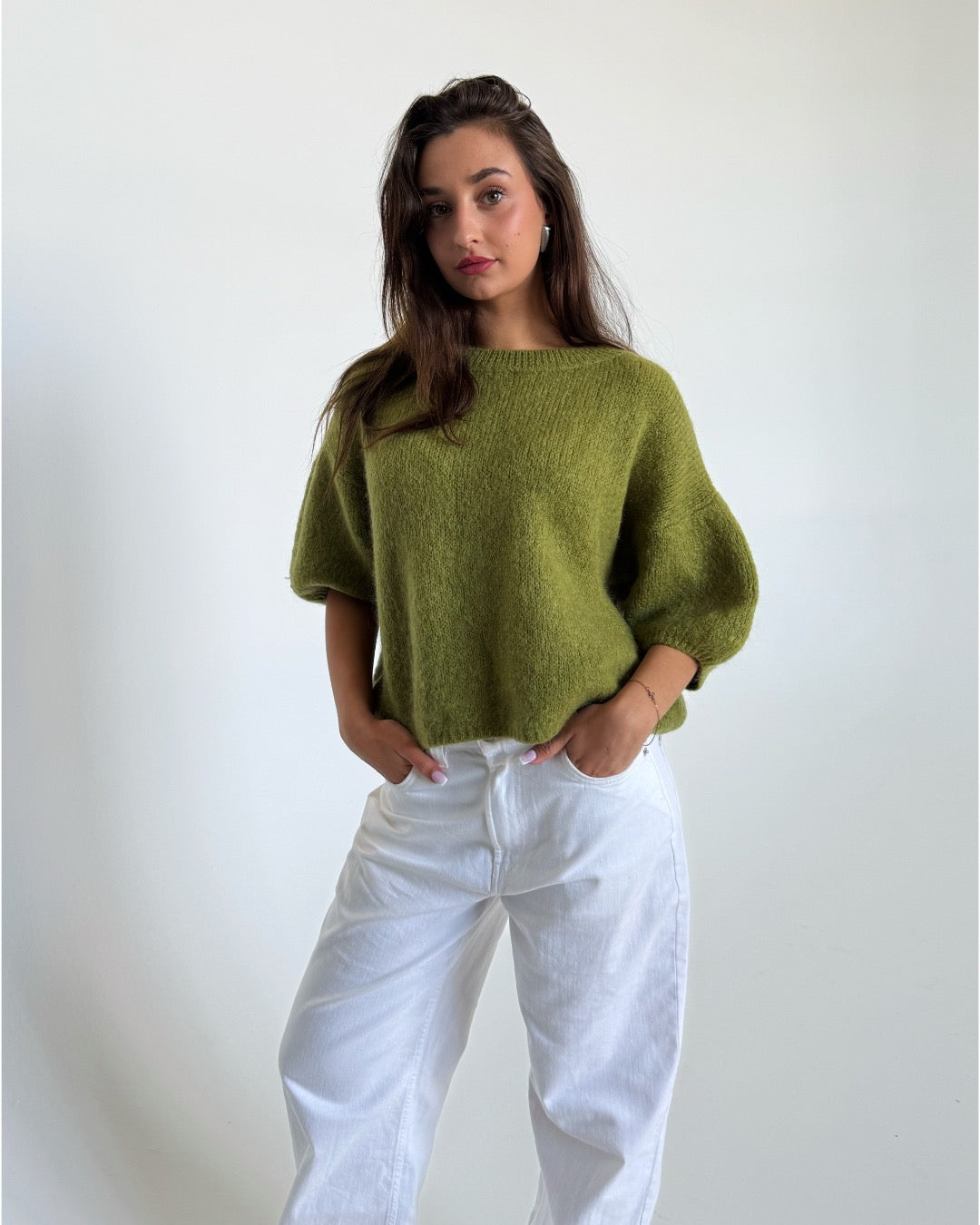Modelfoto af pige i grøn Poppy strik t-shirt og hvide Nanna jeans. Alt er fra BySofieSønderby