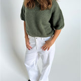 Modelfoto af pige i kaki Poppy strik t-shirt og hvide Nanna jeans. Alt er fra BySofieSønderby