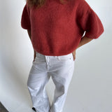 Modelfoto af pige i terracottafarvet Poppy strik t-shirt og hvide Nanna jeans. Alt er fra BySofieSønderby