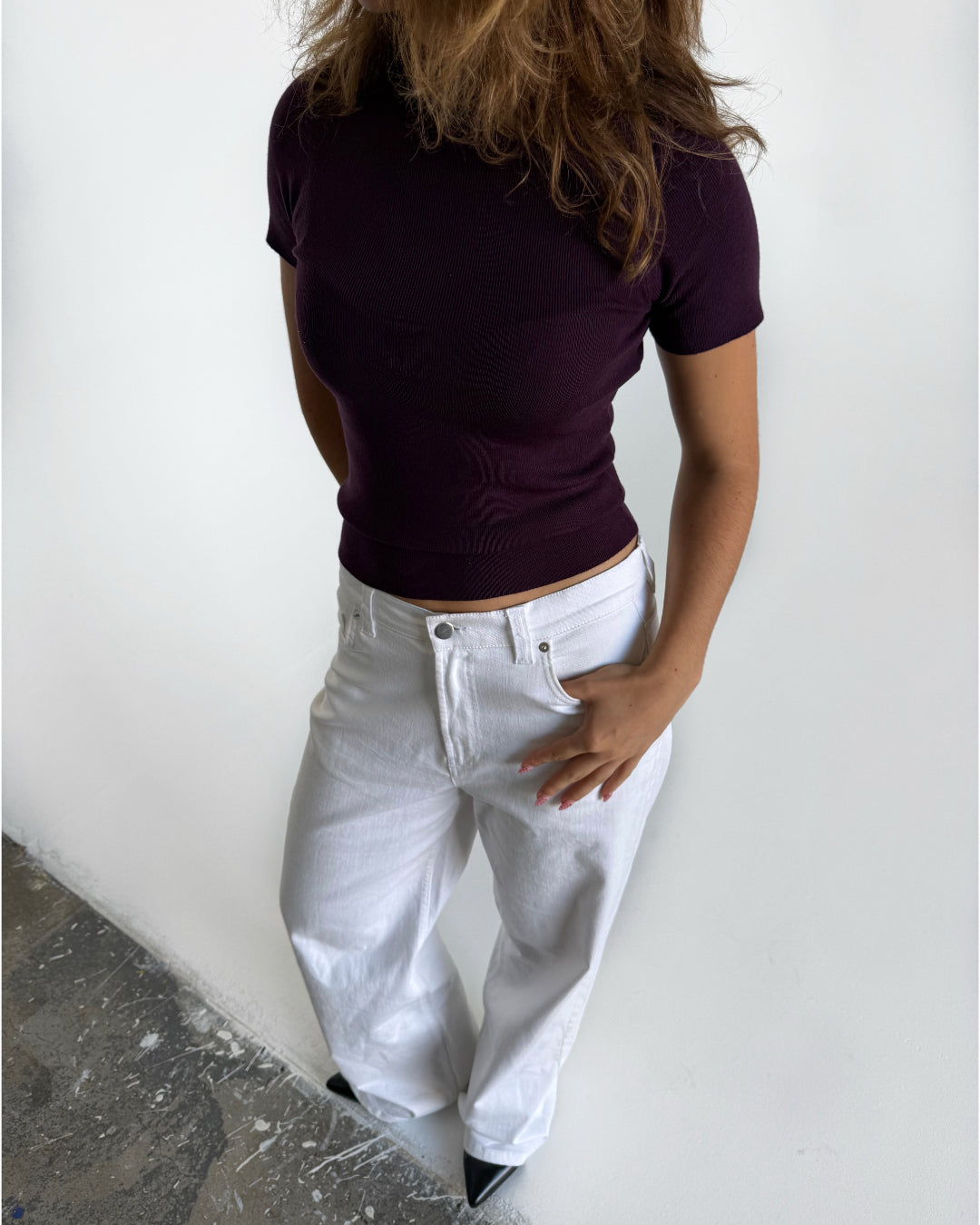 Modelfoto af pige i stramtsiddende kortærmet blommefarvet RIVKA t-shirt, samt hvide NANNA jeans. Alt er fra BySofieSønderby