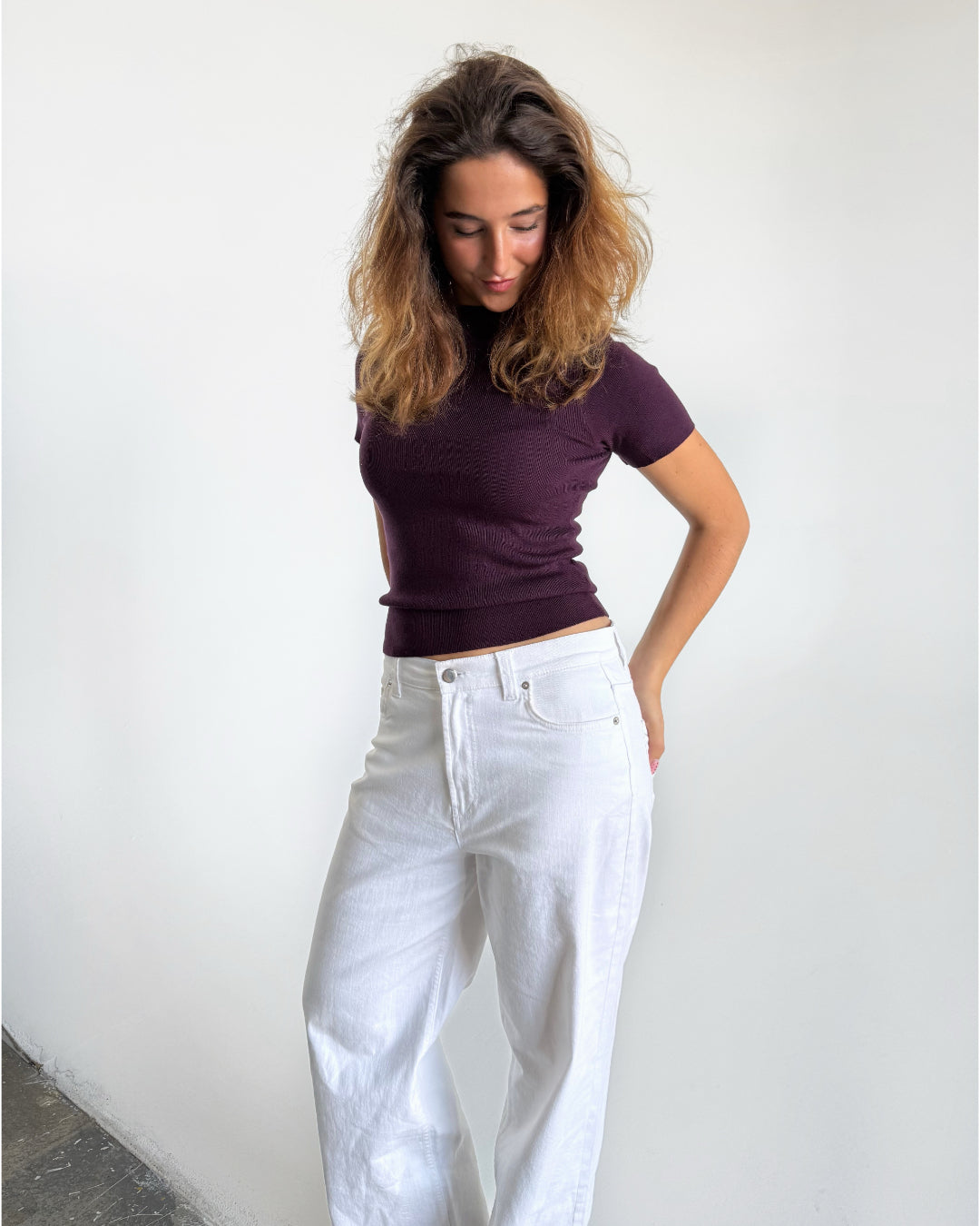 Modelfoto af pige i stramtsiddende kortærmet blommefarvet RIVKA t-shirt, samt hvide NANNA jeans. Alt er fra BySofieSønderby