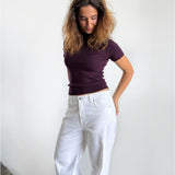 Modelfoto af pige i stramtsiddende kortærmet blommefarvet RIVKA t-shirt, samt hvide NANNA jeans. Alt er fra BySofieSønderby